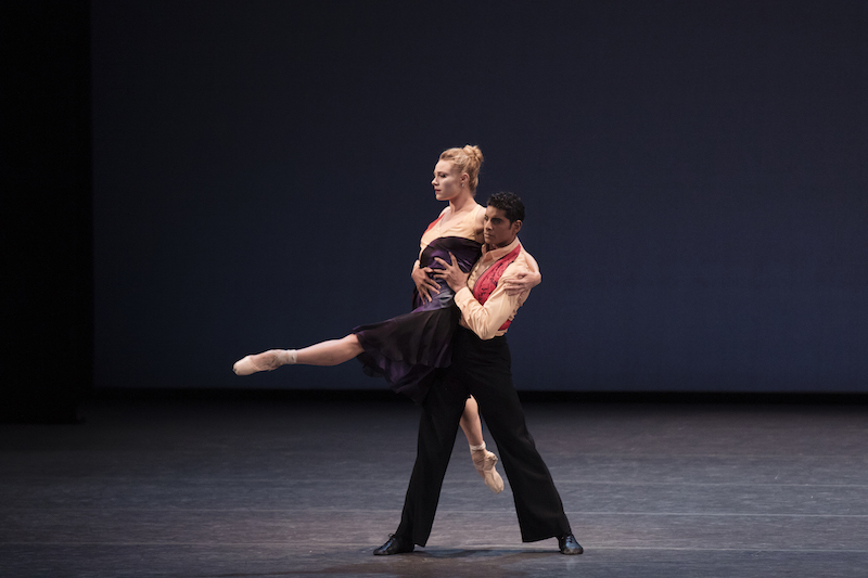 Amar Ramasar lifts Sara Mearns from her waist. Her left leg outstretched in front of her, Sara holds onto Amar's shoulder. She looks like she's floating in midair.